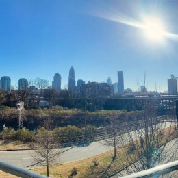 Live at Cadence Music Factory  A view of the city skyline in Charlotte, NC set against a sunny, cloudless sky.