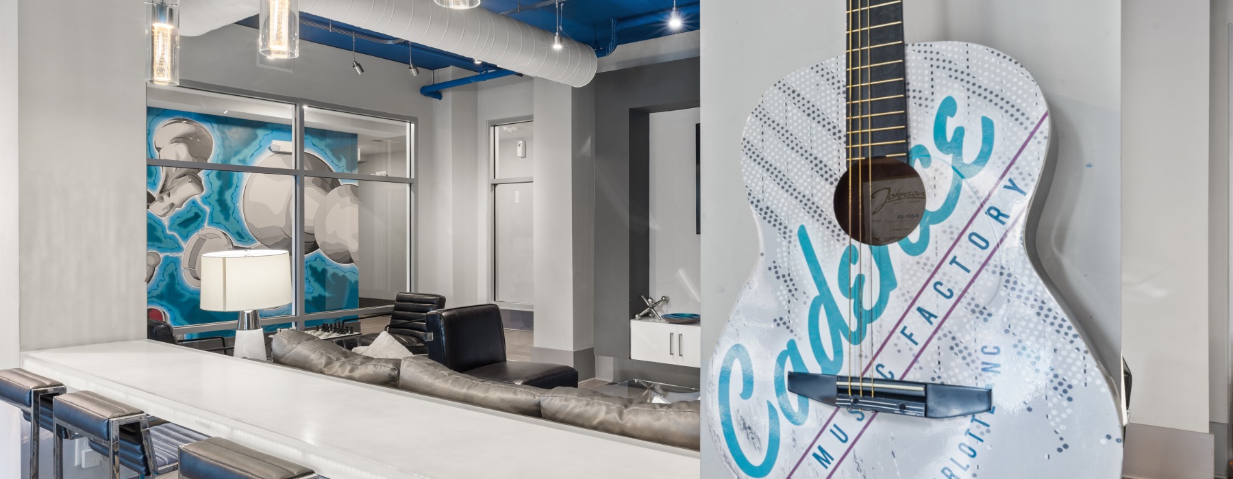 Guitar on a wall next to bar top with chair in a lounge