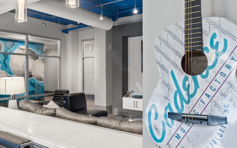 Guitar on a wall next to bar top with chair in a lounge